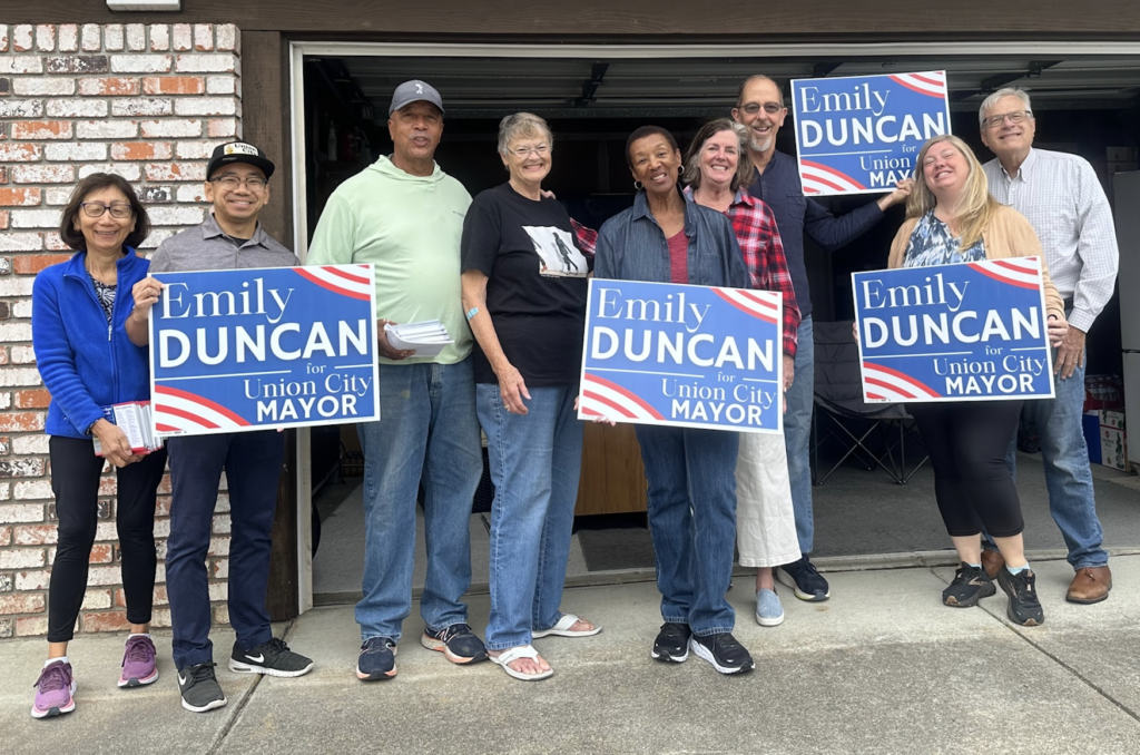 Emily Duncan for Union City Mayor supporters holding yard signs.